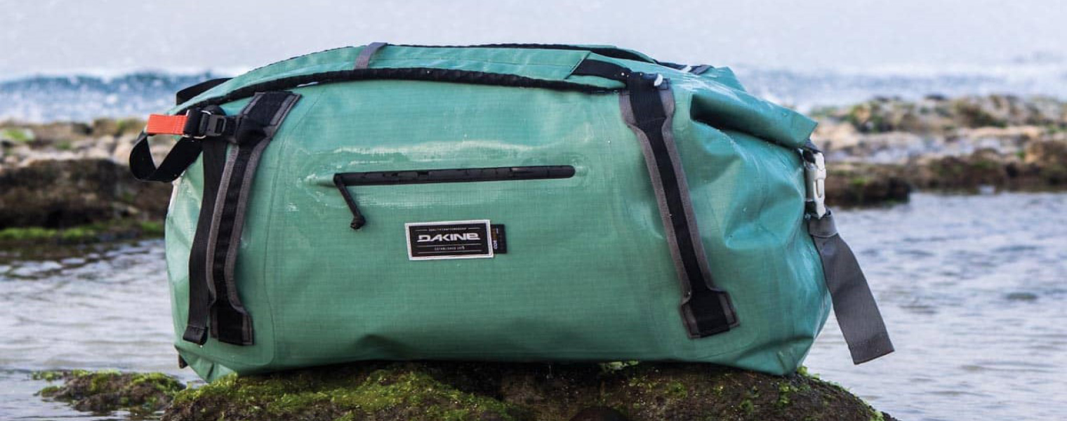 Dakine duffle bag at beach in greenish blue