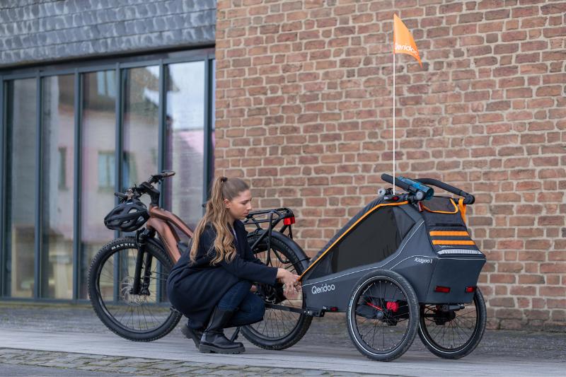 Qeridoo Buggy behind bike with woman 
