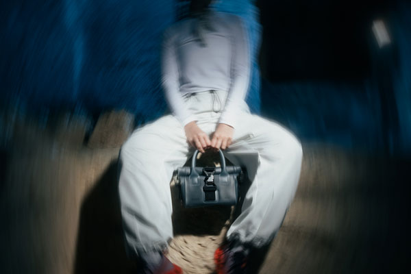 person holding tomoe handbag with fidlock v-buckle
