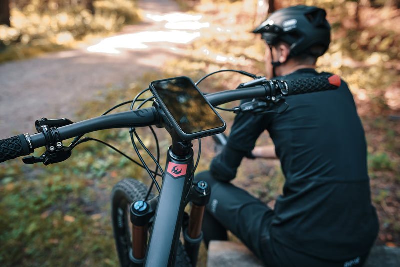 Man sitting next to bike with Cellphone on it