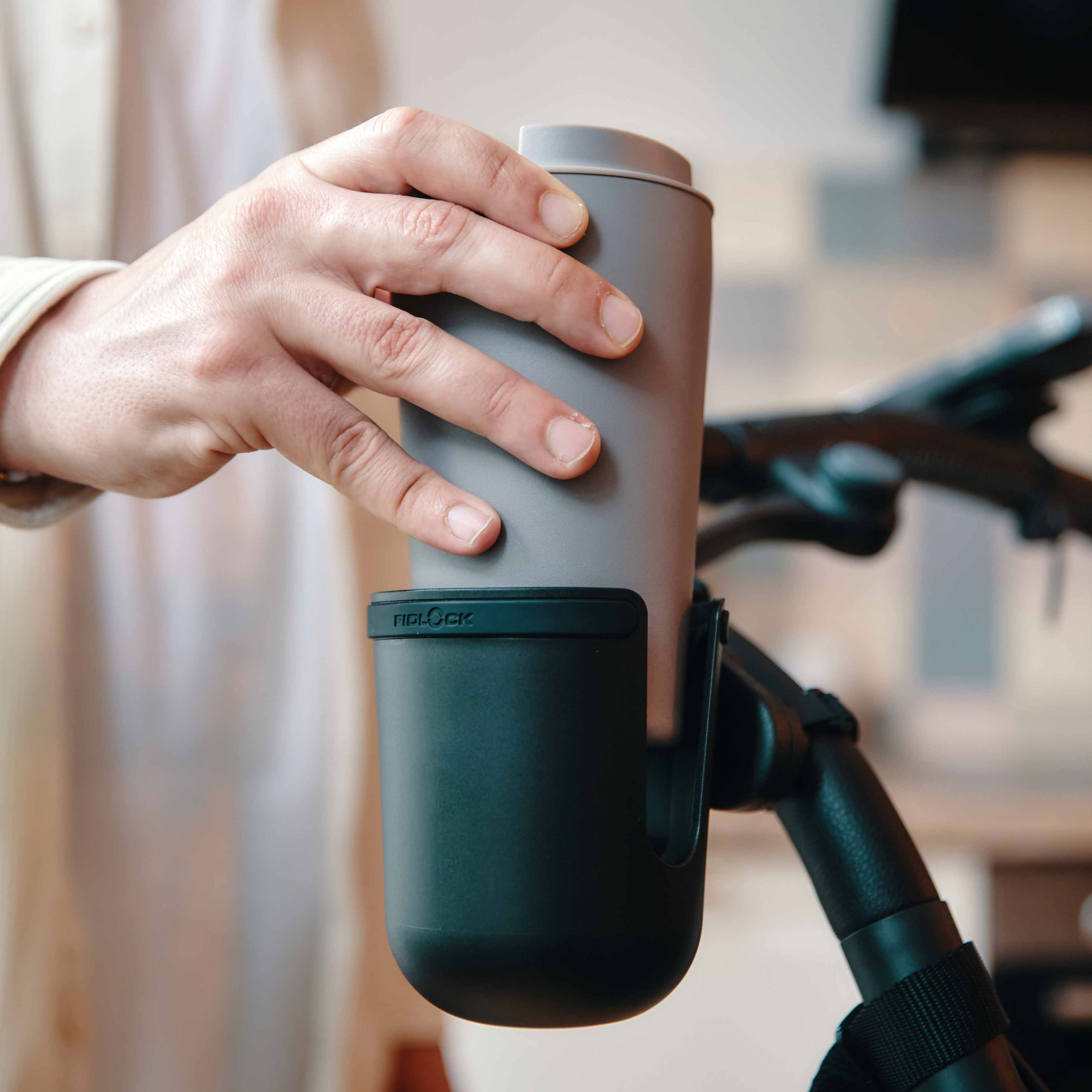 FIDLOCK_TWIST_cup holder-am-Kinderwagen-Kaffeebecher-wird-hineingestellt