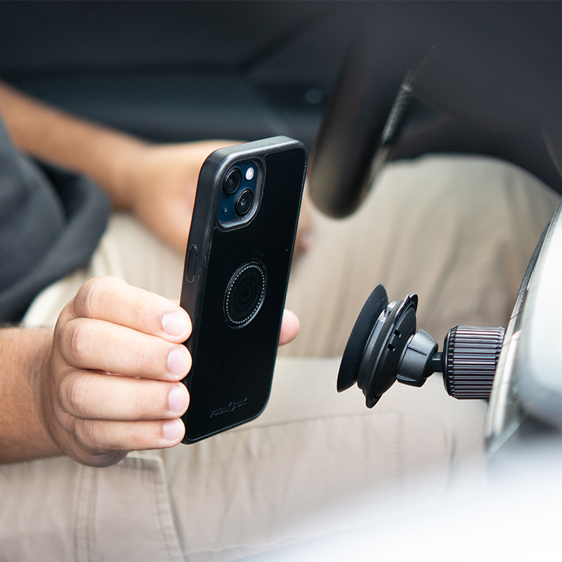 FIDLOCK-VACUUM-car-suction-base-im-Auto-mit-Handy-davorgehalten-seitliche-Ansicht